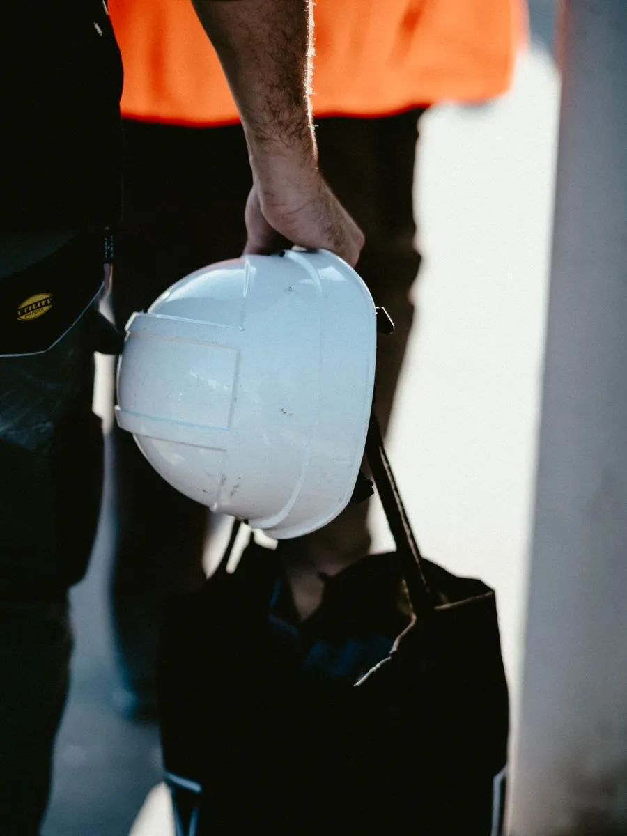 Worker holding a white safety helmet on site